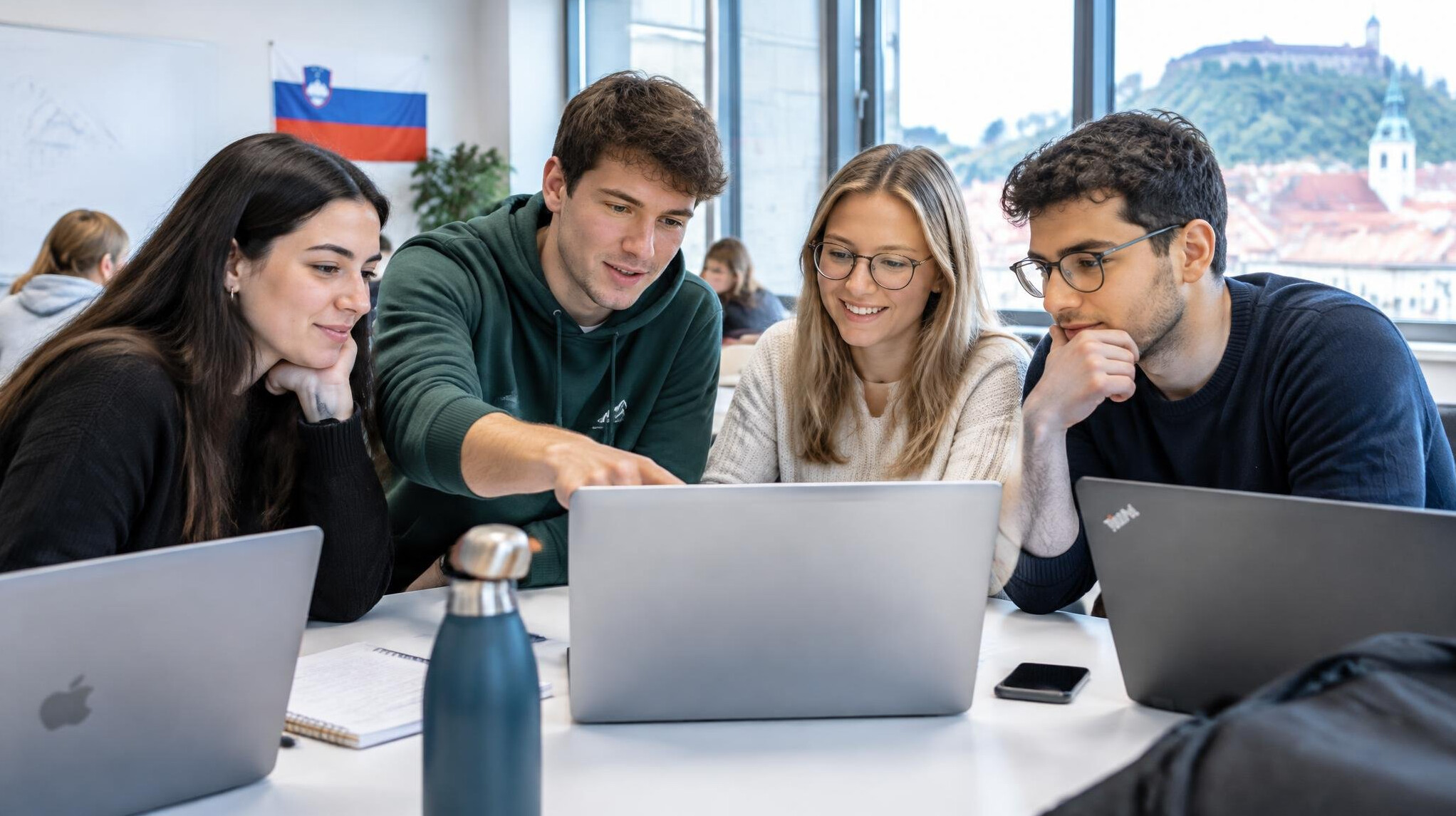 Group of students collaborating on laptops in a classroom
