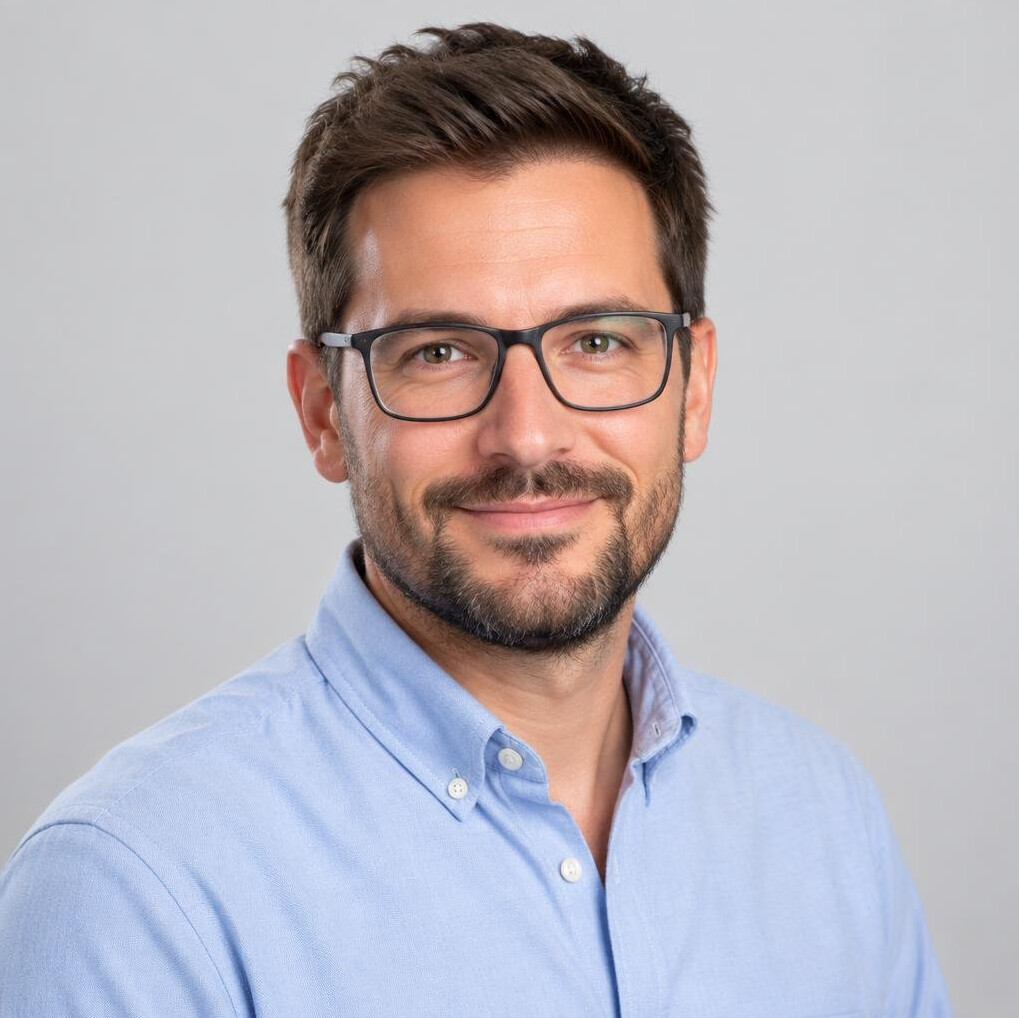 Studio portrait of a bearded man with glasses